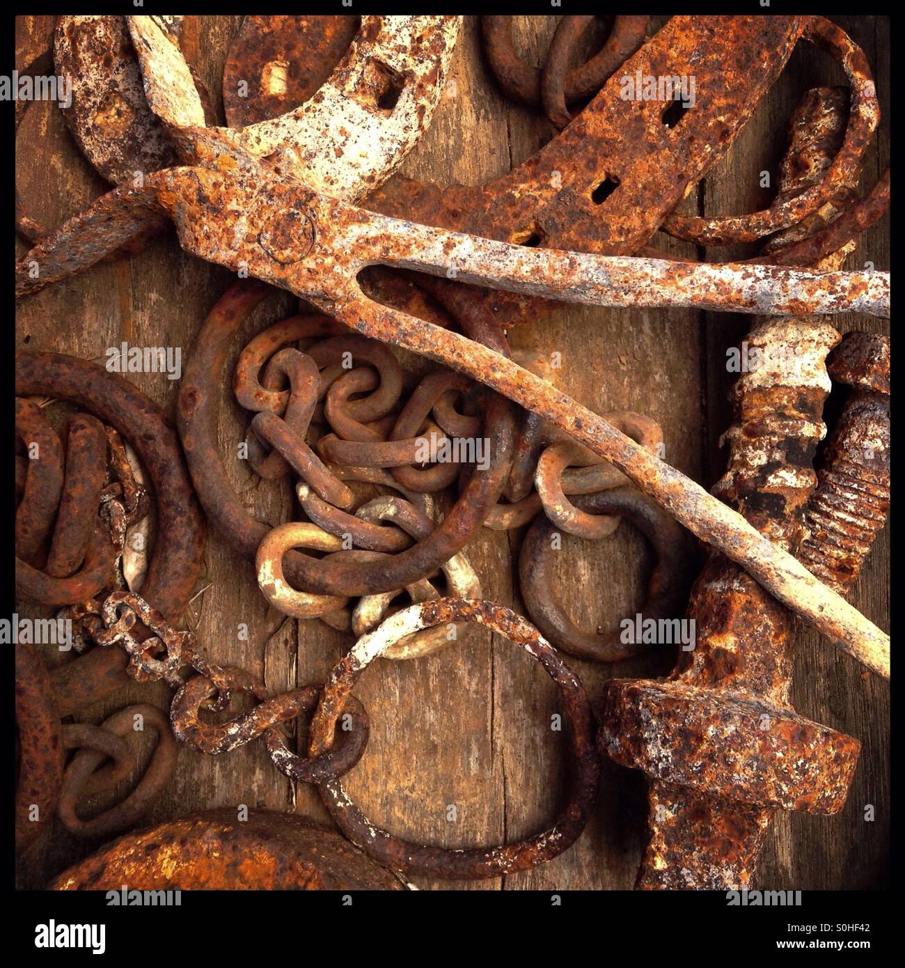 Rusty metal objects collected on a wooden barrel, Catalonia, Spain. - Smartphone Captured Stock Image