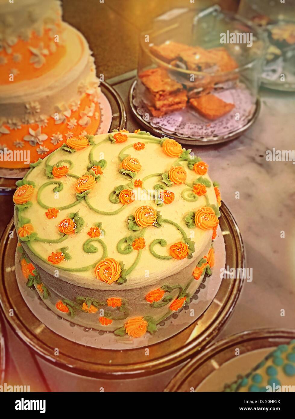 Brightly decorated layer cakes in bakery display case Stock Photo Alamy