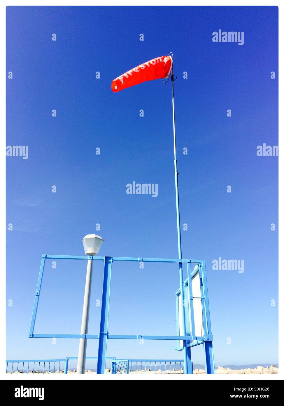 Red windsock in the new harbour in Hermanus, South Africa. - Smartphone Captured Stock Image
