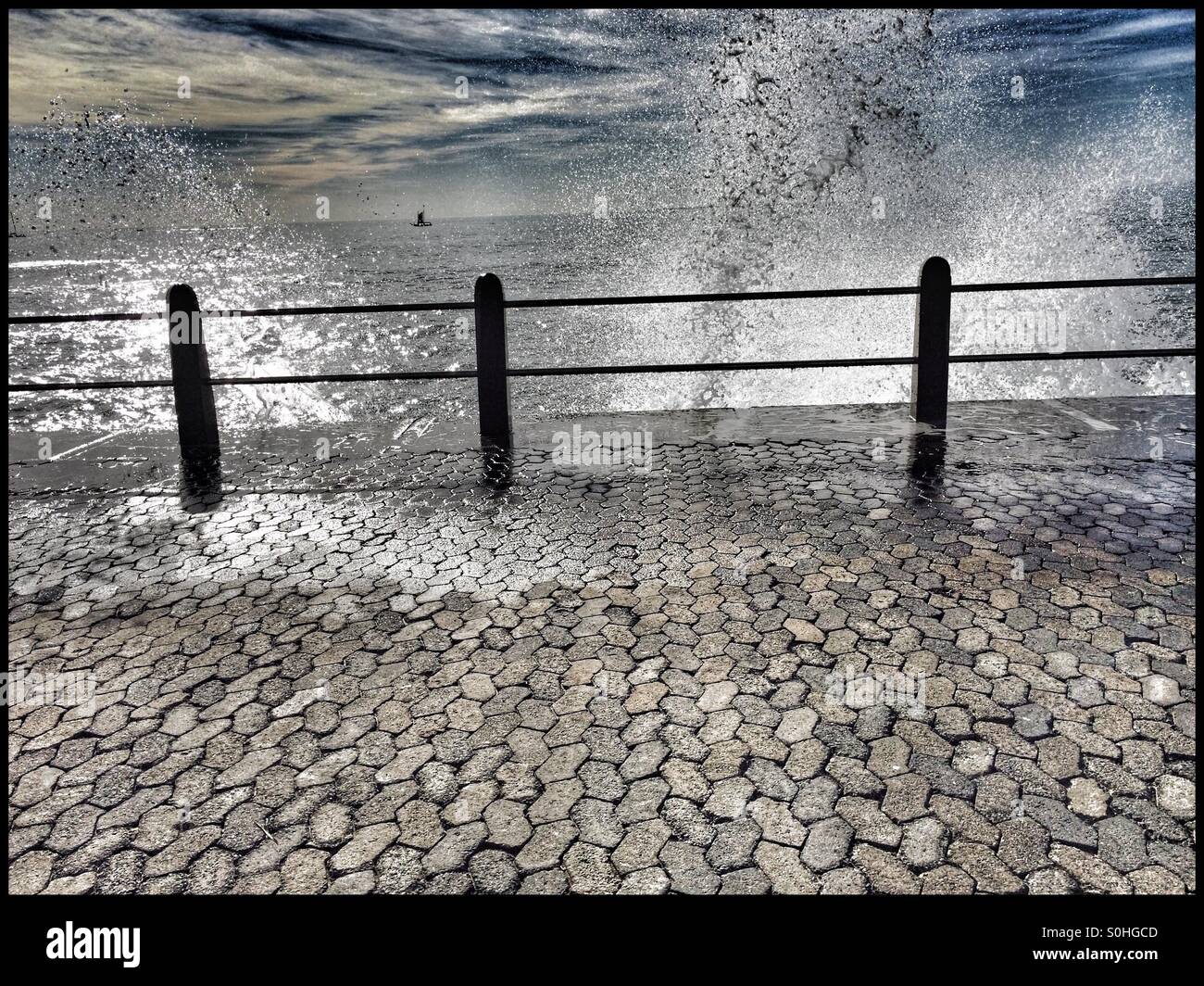 Wave breaking over railing at Seapoint promenade . - Smartphone Captured Stock Image