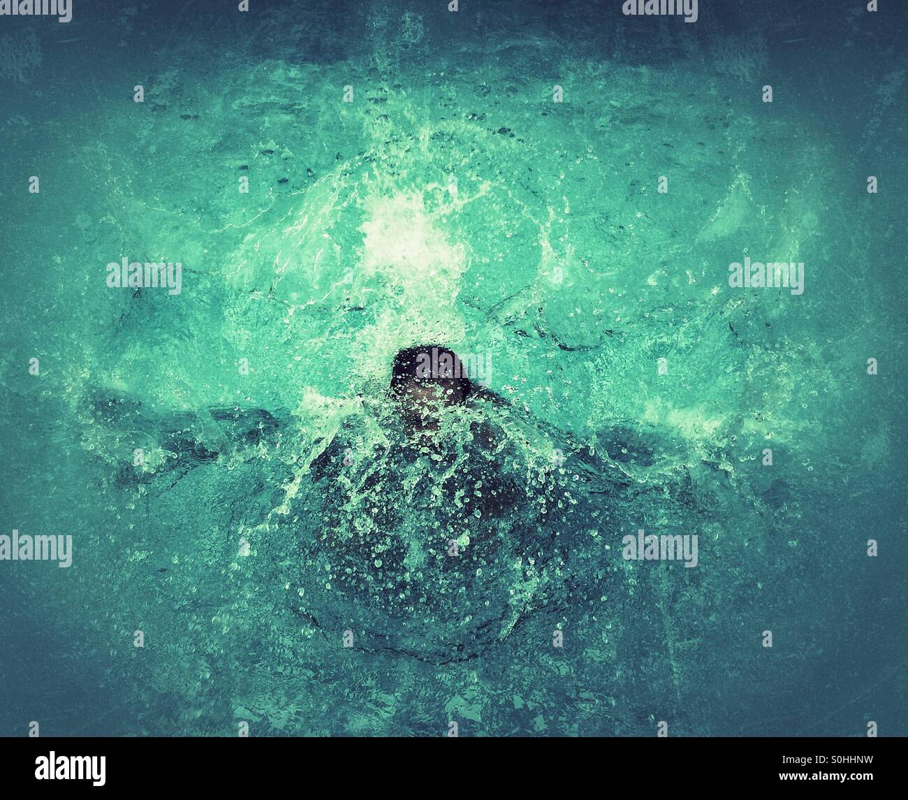 Man diving into a swimming pool Stock Photo