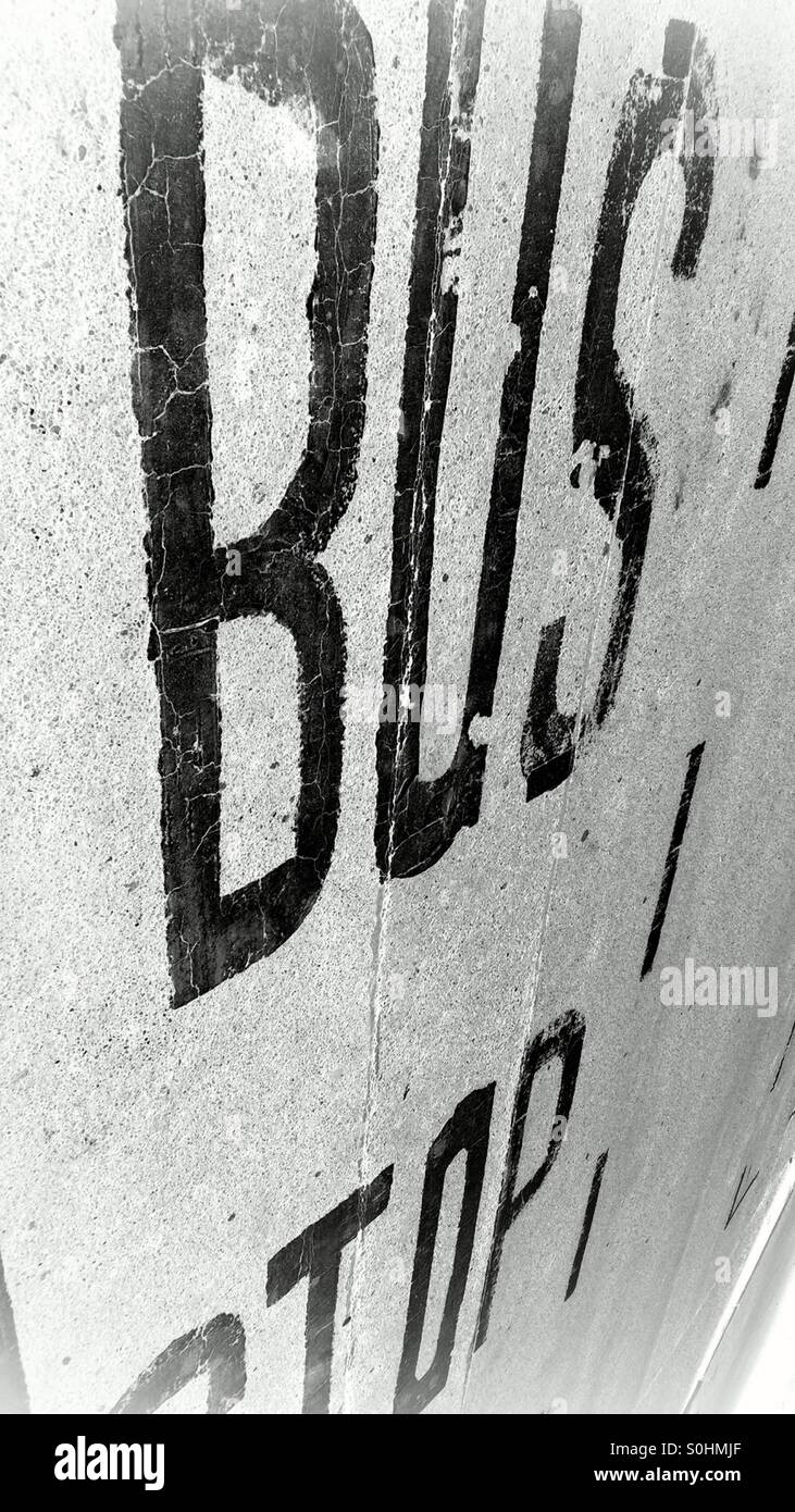 Bus stop sign on road in black and white - Smartphone Captured Stock Image