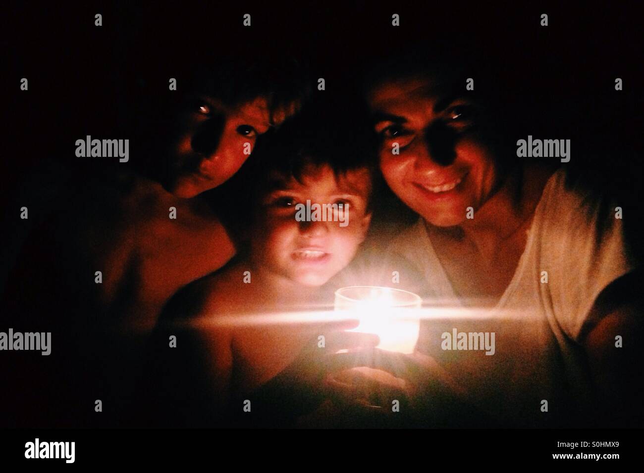 Portrait of a woman and two children with a candle ligh Stock Photo