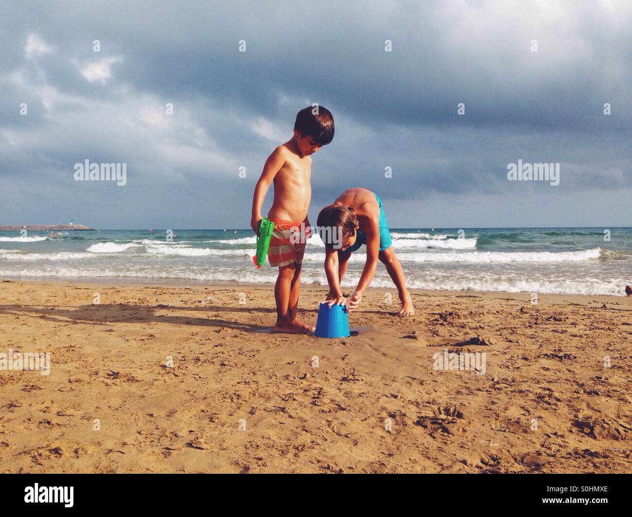 Two children playing on the beach Stock Photo