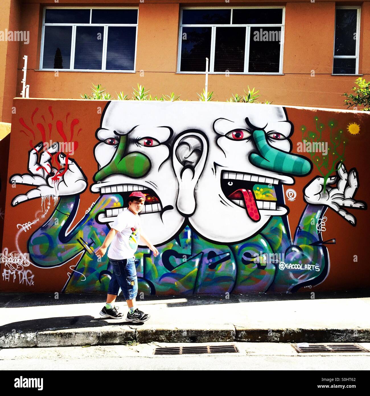 Sao Paulo - May 23: Unknown child in front of graffiti wall on the streets of Vila Madalena neighborhood on May 23, 2015 in Sao Paulo, Brazil Stock Photo