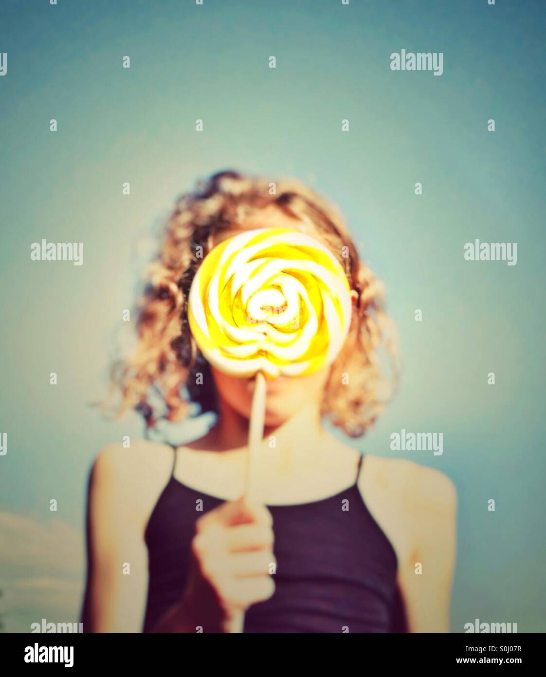 Young girl holding candy lolly in front of her face Stock Photo