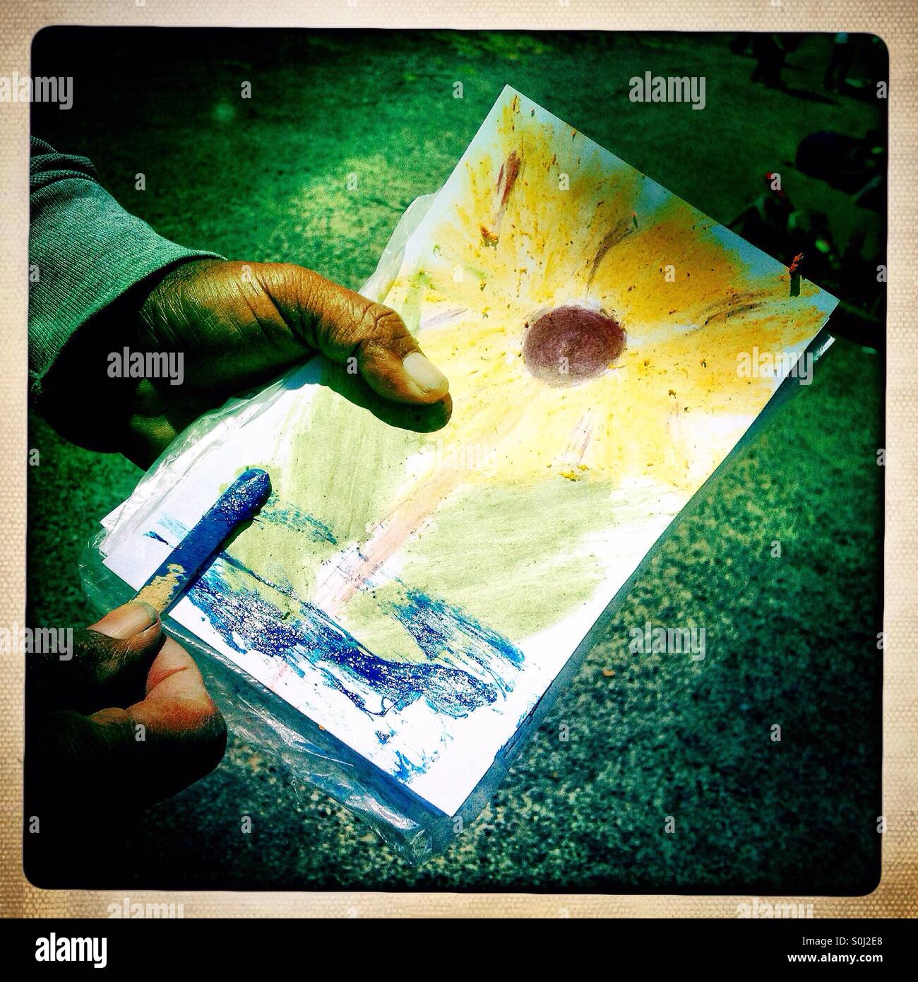 A tourist guide paints using lapis lazuli mineral as he shows ancient indigenous painting techniques in Teotihuacan, Mexico - Smartphone Captured Stock Image