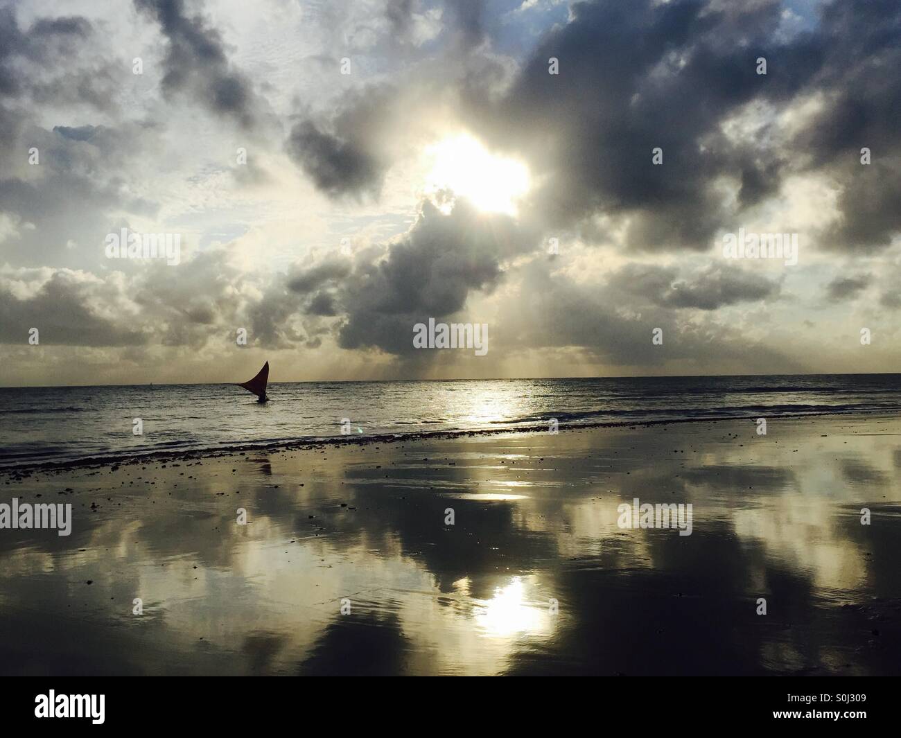 Sky and boat reflection on the ocean shore at sunrise Stock Photo - Alamy