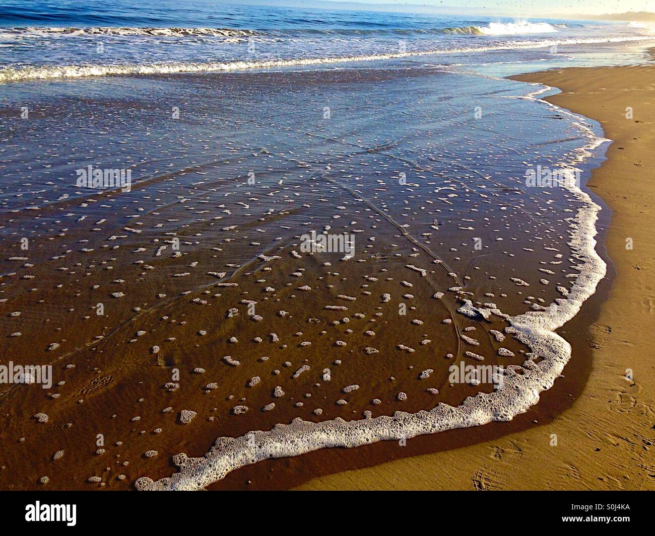 Gentle waves over a sandy ocean shore - Smartphone Captured Stock Image