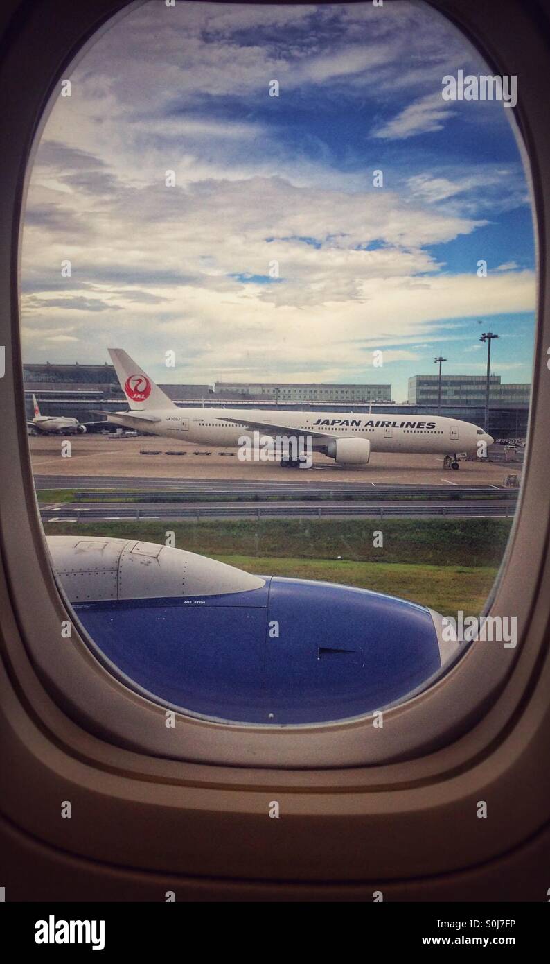 Japan Airlines Boeing 777 parked at an airport through an aircraft window Stock Photo