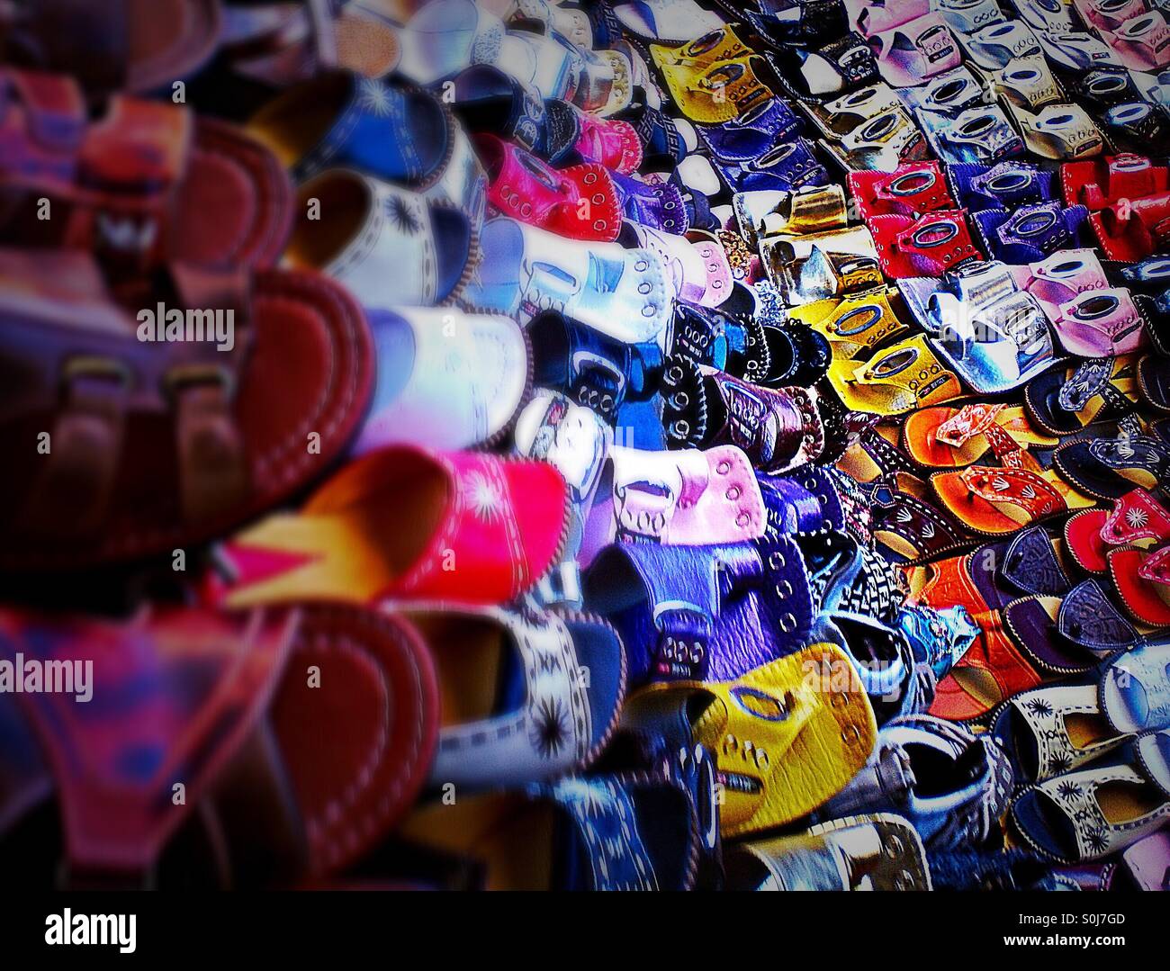 Multi coloured sandals and shoes for sale market stall - Smartphone Captured Stock Image
