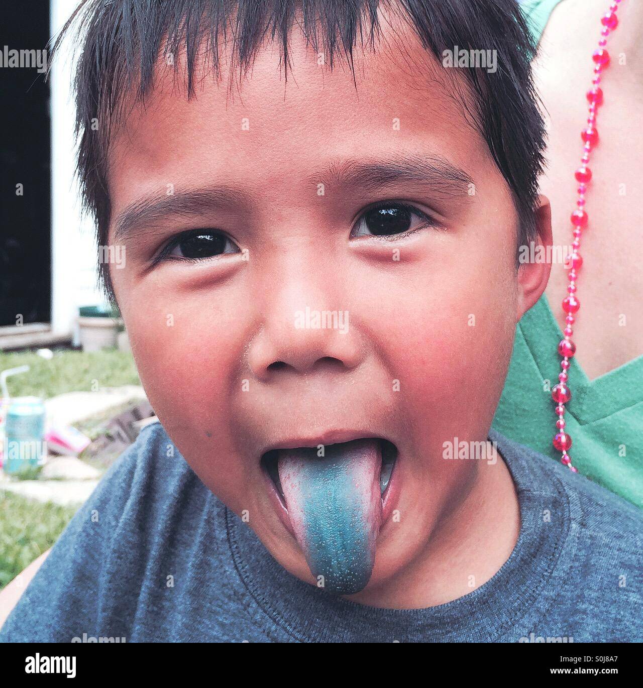 A little boy sticks out his blue tongue Stock Photo Alamy