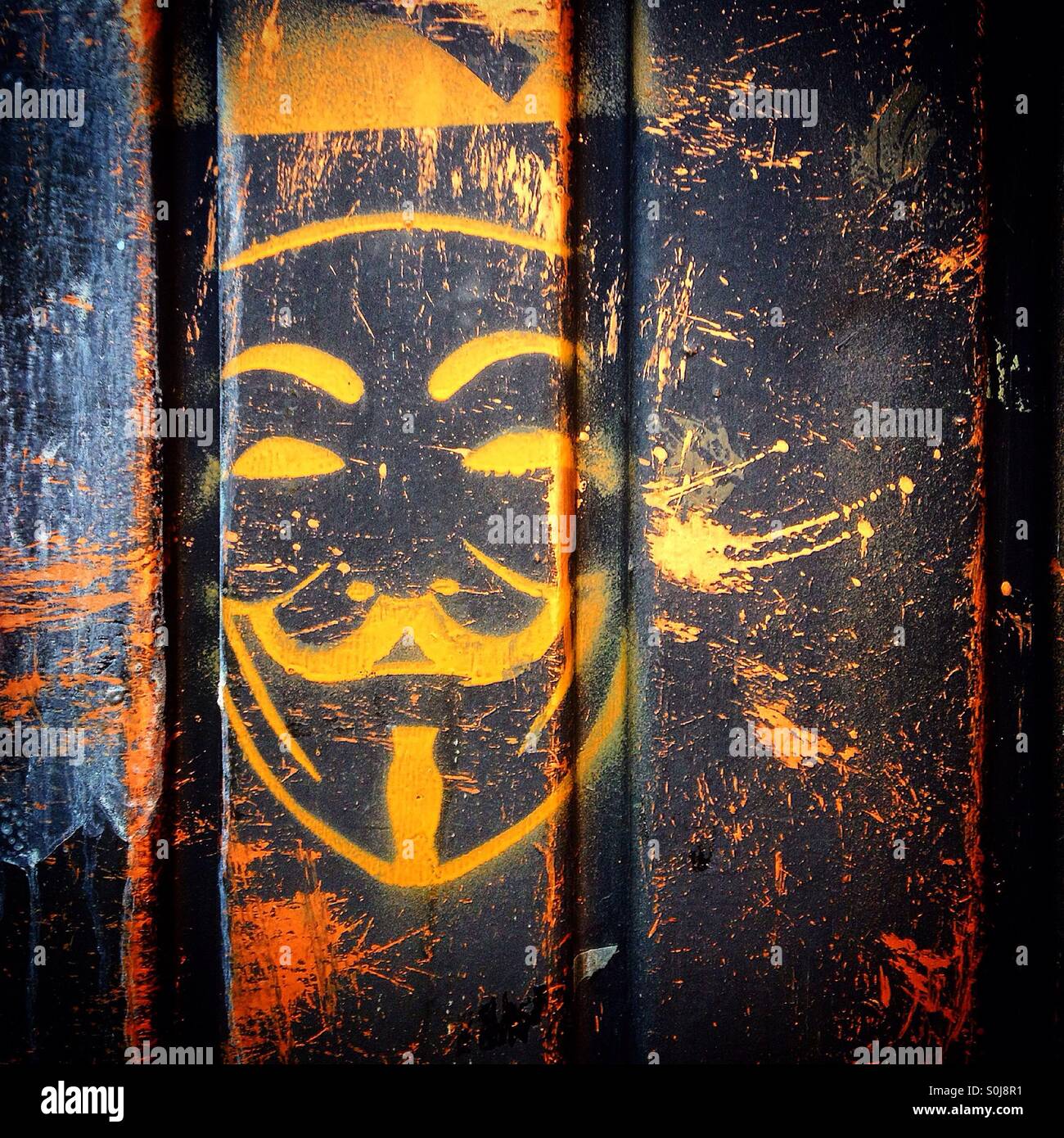 A graffiti with an orange anonymous face decorates a wall in Mexico City, Mexico - Smartphone Captured Stock Image