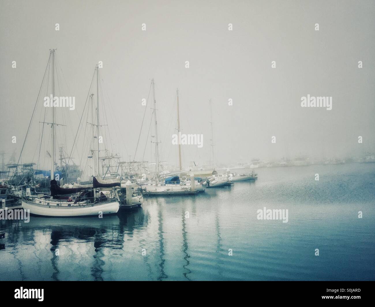 Boats Docked At The Harbor In The Misty Fog. Generic/Any Names And Numbers Taken Out. Stock Photo