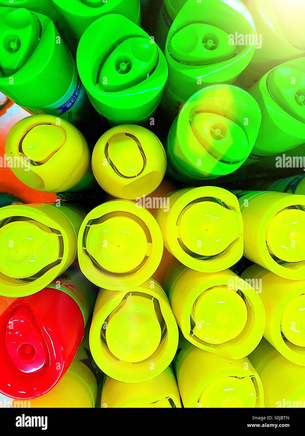 Tops of brightly colored aerosol cans. - Smartphone Captured Stock Image