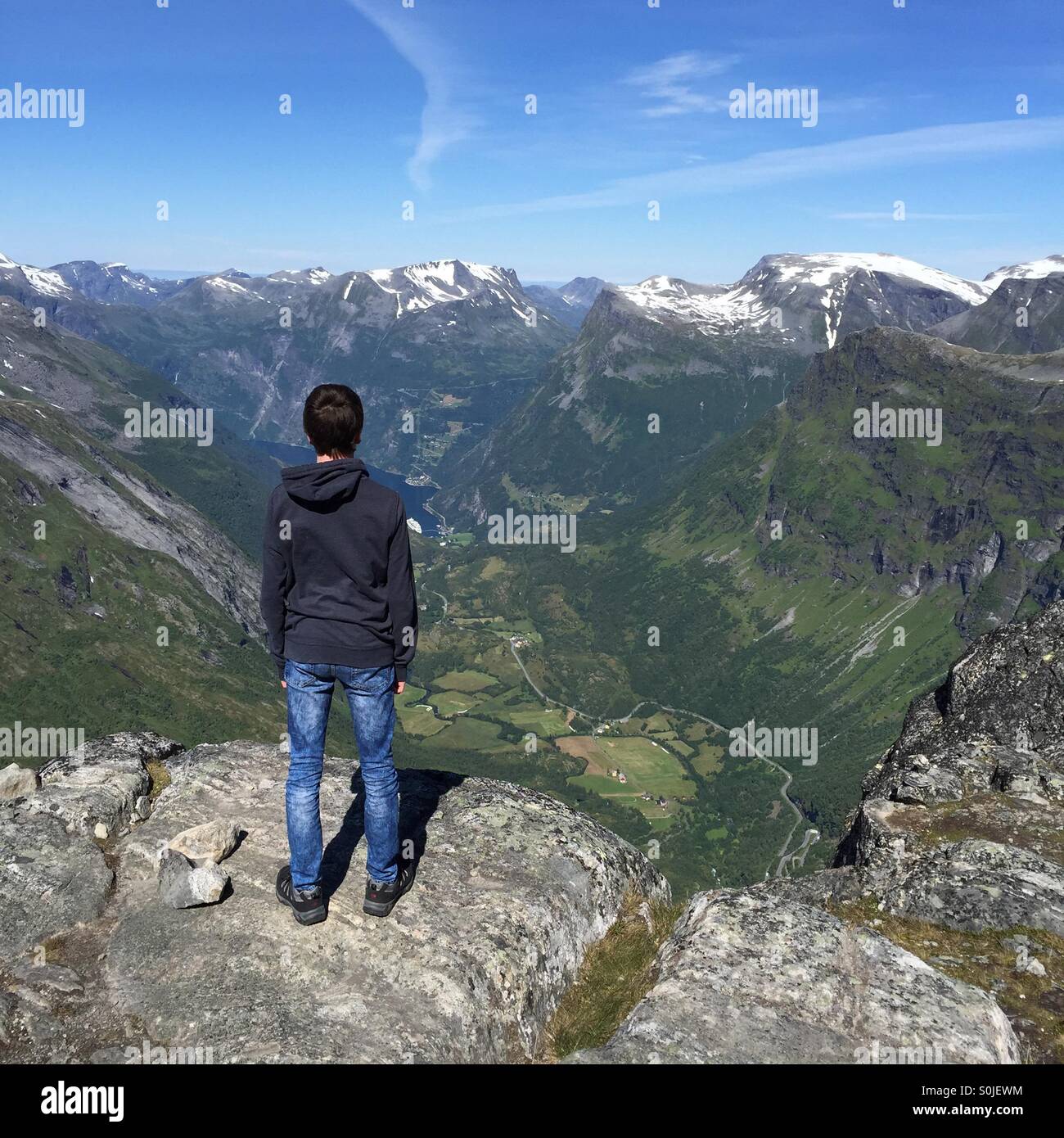 Boy looking down at Geiranger from Dalsnibba, Norway Stock Photo