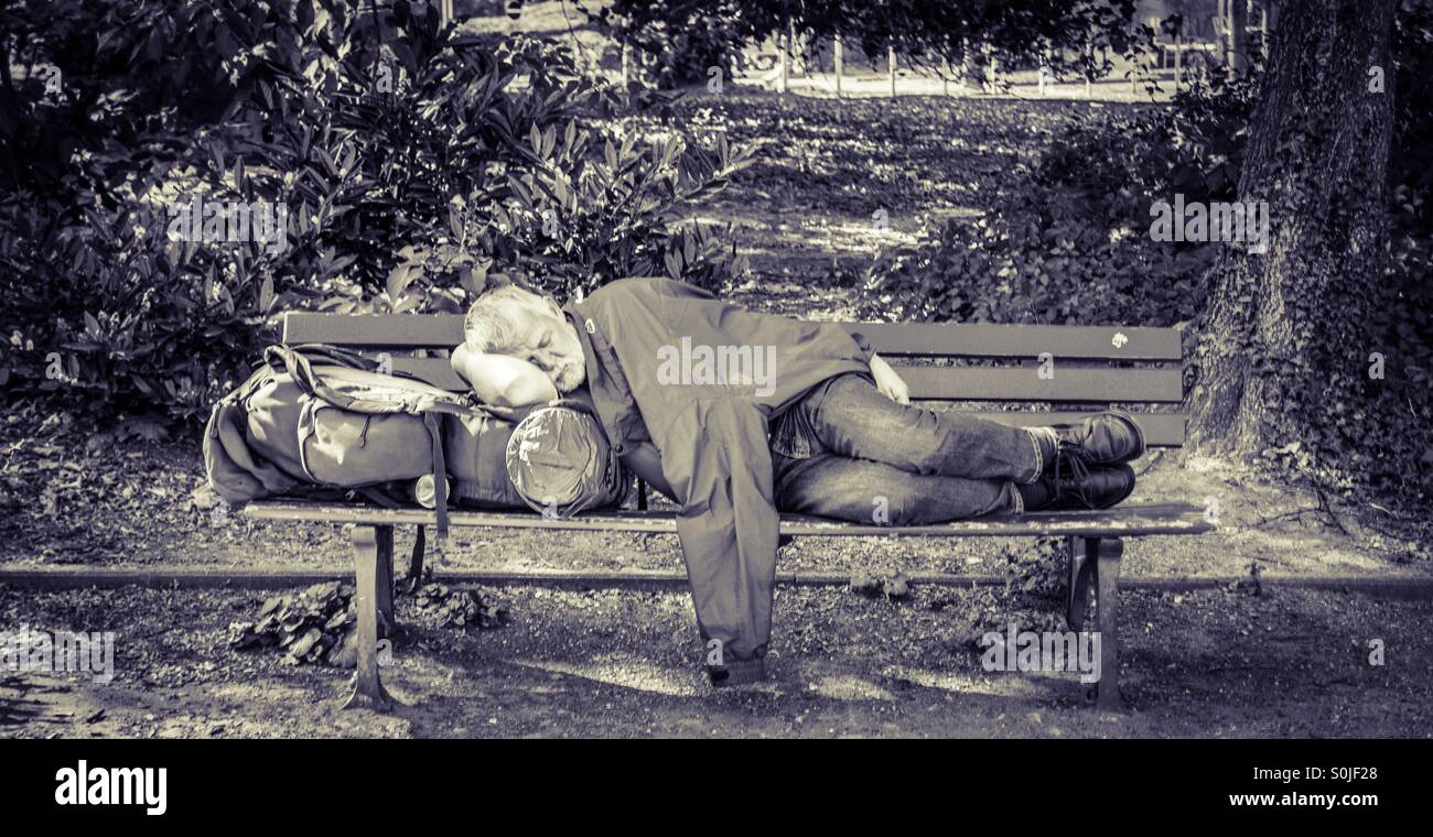 Homeless man sleeps on park bench Stock Photo - Alamy