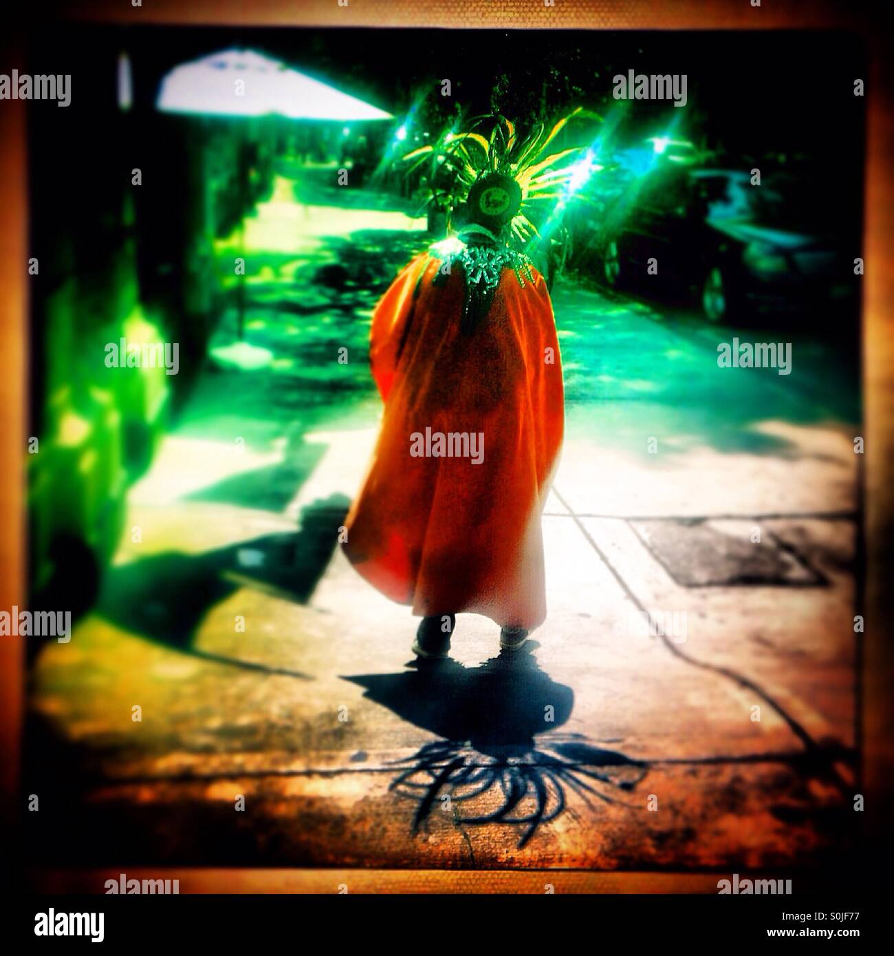 A man dressed as and Aztec ruler dances as he asks for money in Colonia Roma, Mexico City, Mexico - Smartphone Captured Stock Image