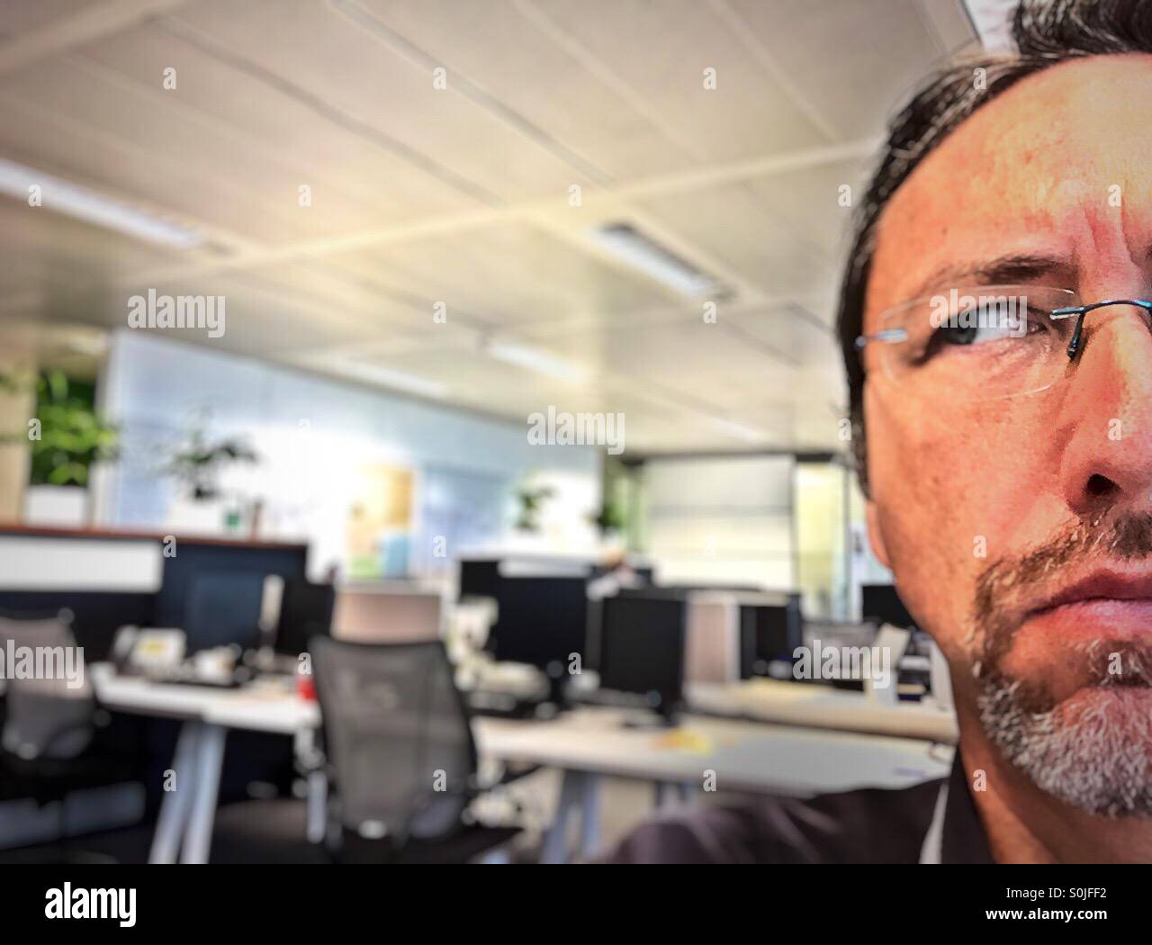 Man in an empty office space looking angry or questioning - Smartphone Captured Stock Image