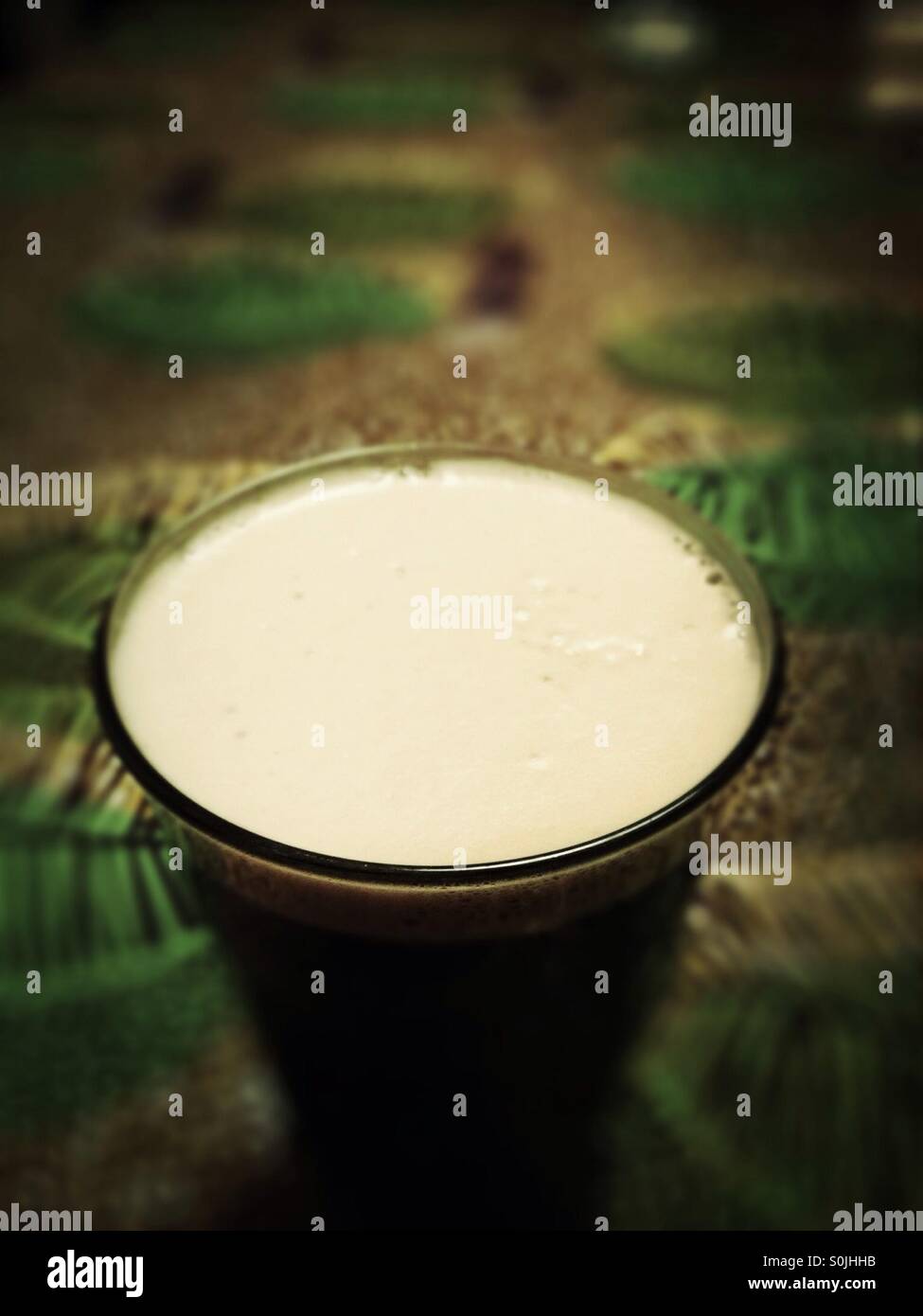 Full glass of stout beer with creamy microbubble head - Smartphone Captured Stock Image