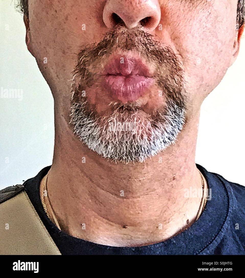 Cut of portrait of a man with a greying goatee making a kissing mouth Stock Photo