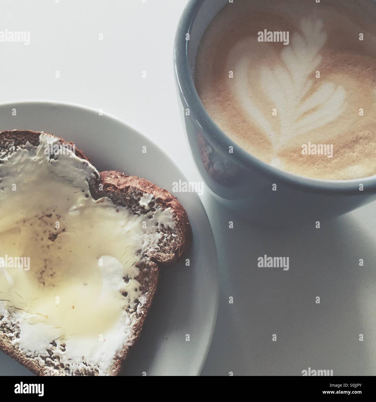 Breakfast- Cream cheese and honey on toast, and a latte. Stock Photo