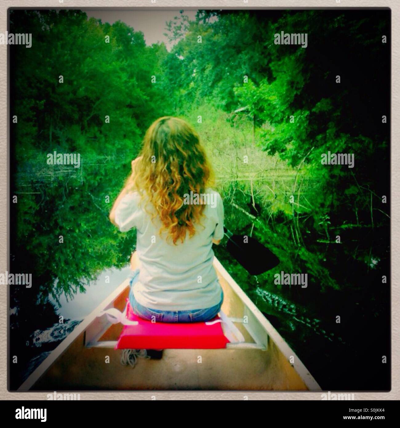 Woman paddling a canoe Stock Photo