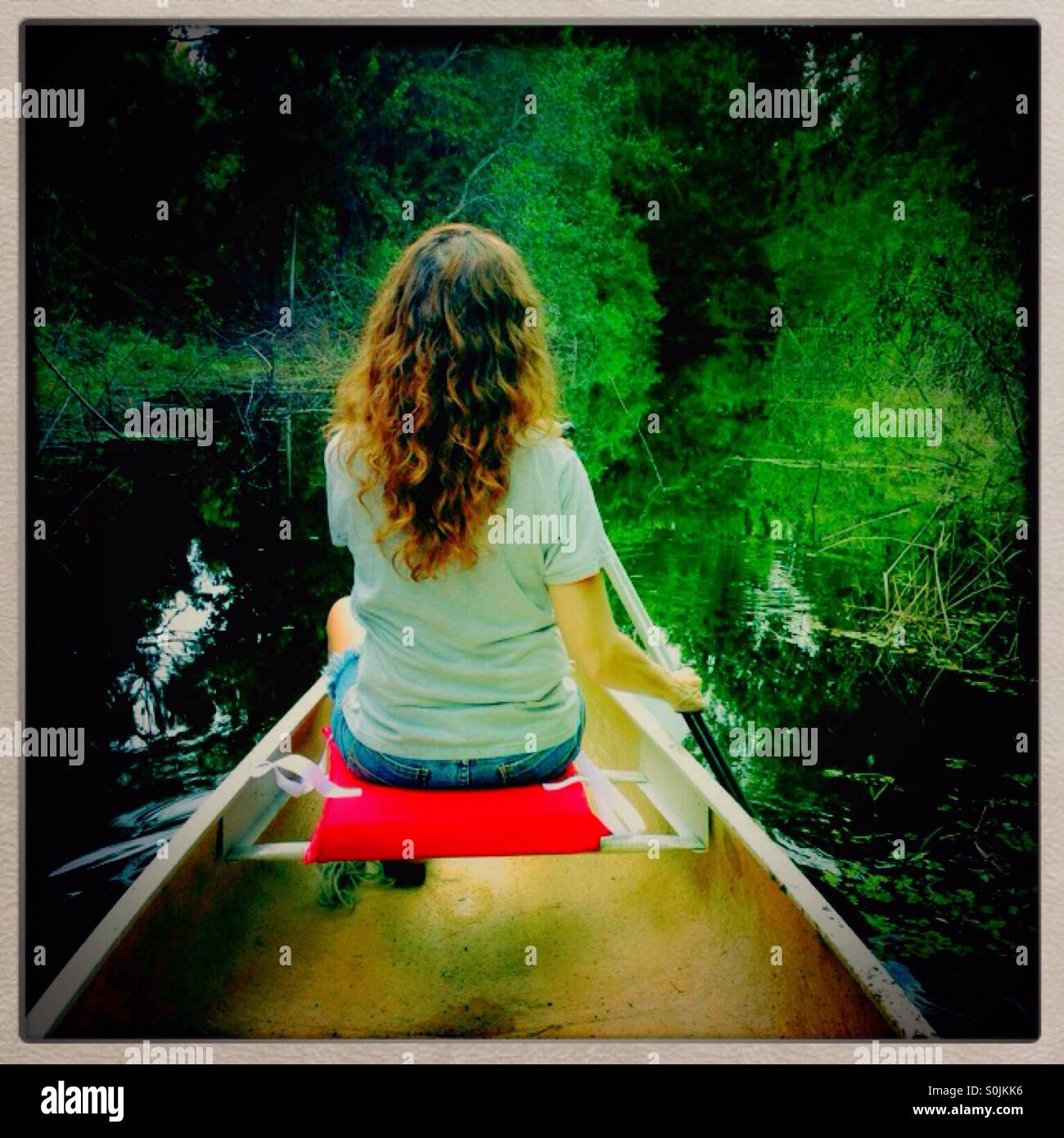 Woman paddling a canoe Stock Photo