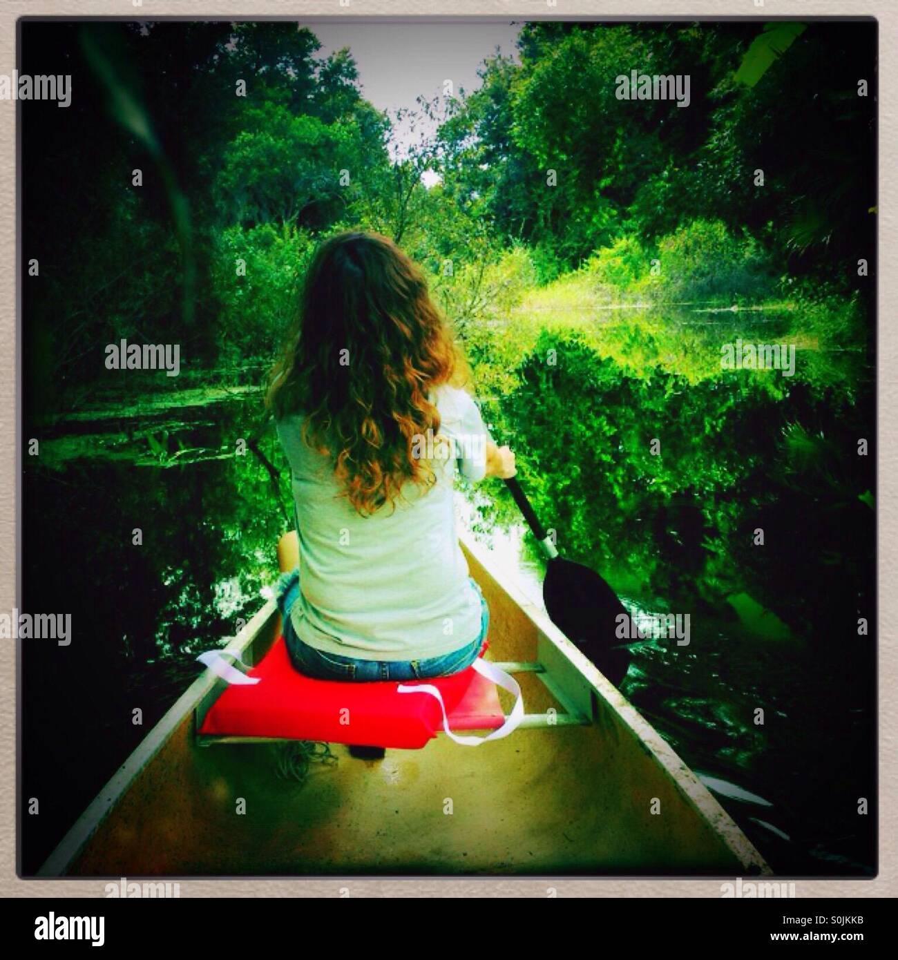 Woman paddling a canoe Stock Photo