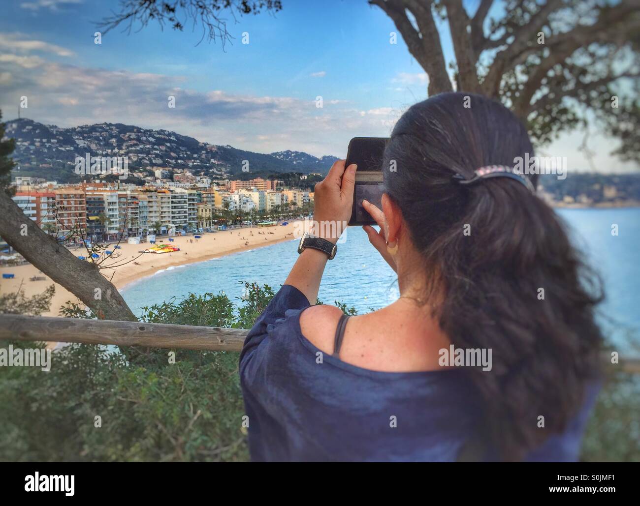 Woman taking a picture on a beach,Lloret de mar,Costa Brava,Spain Stock Photo