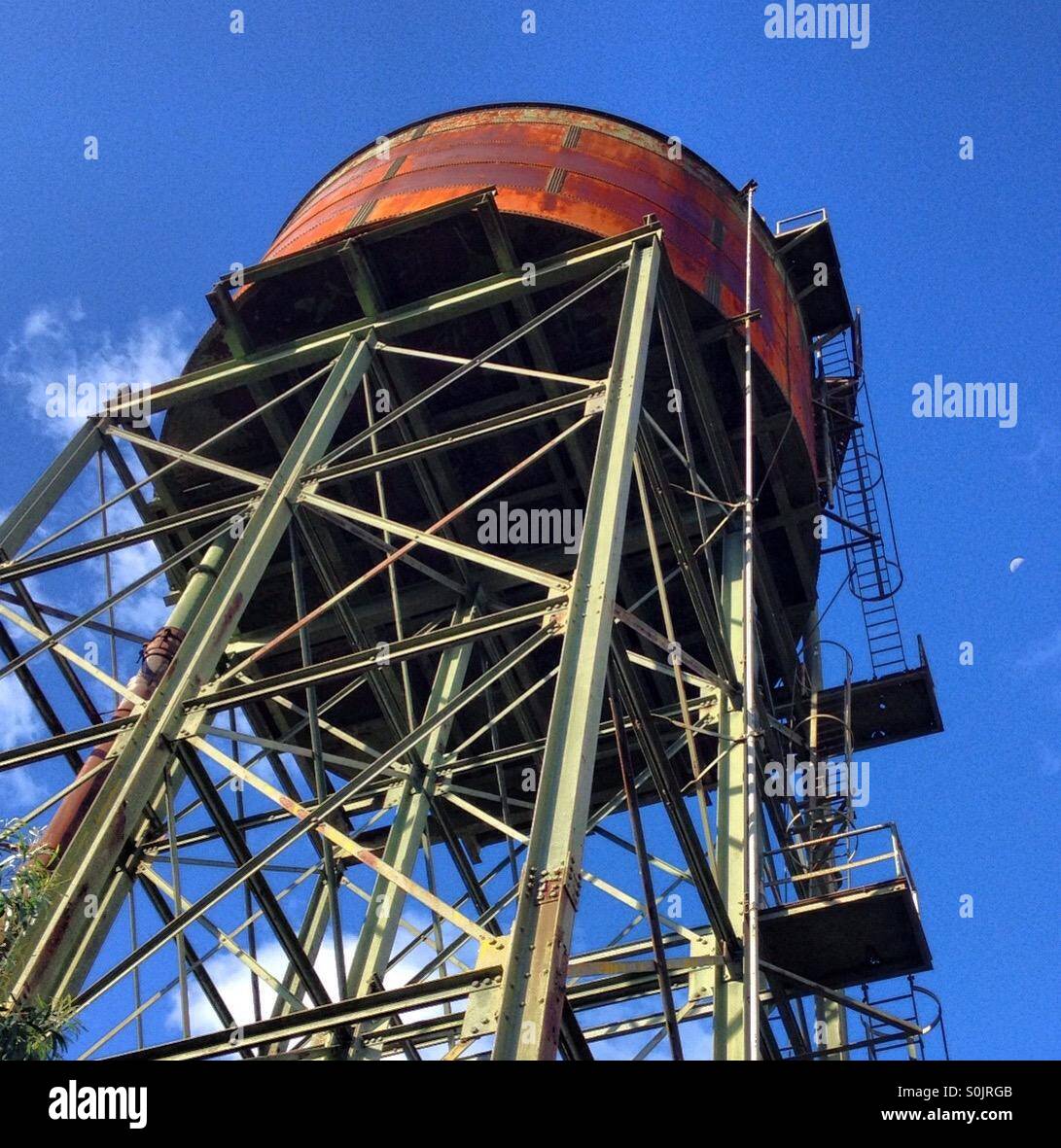 Looking up at at a large rusty water tank mounted on a steel tower - Smartphone Captured Stock Image