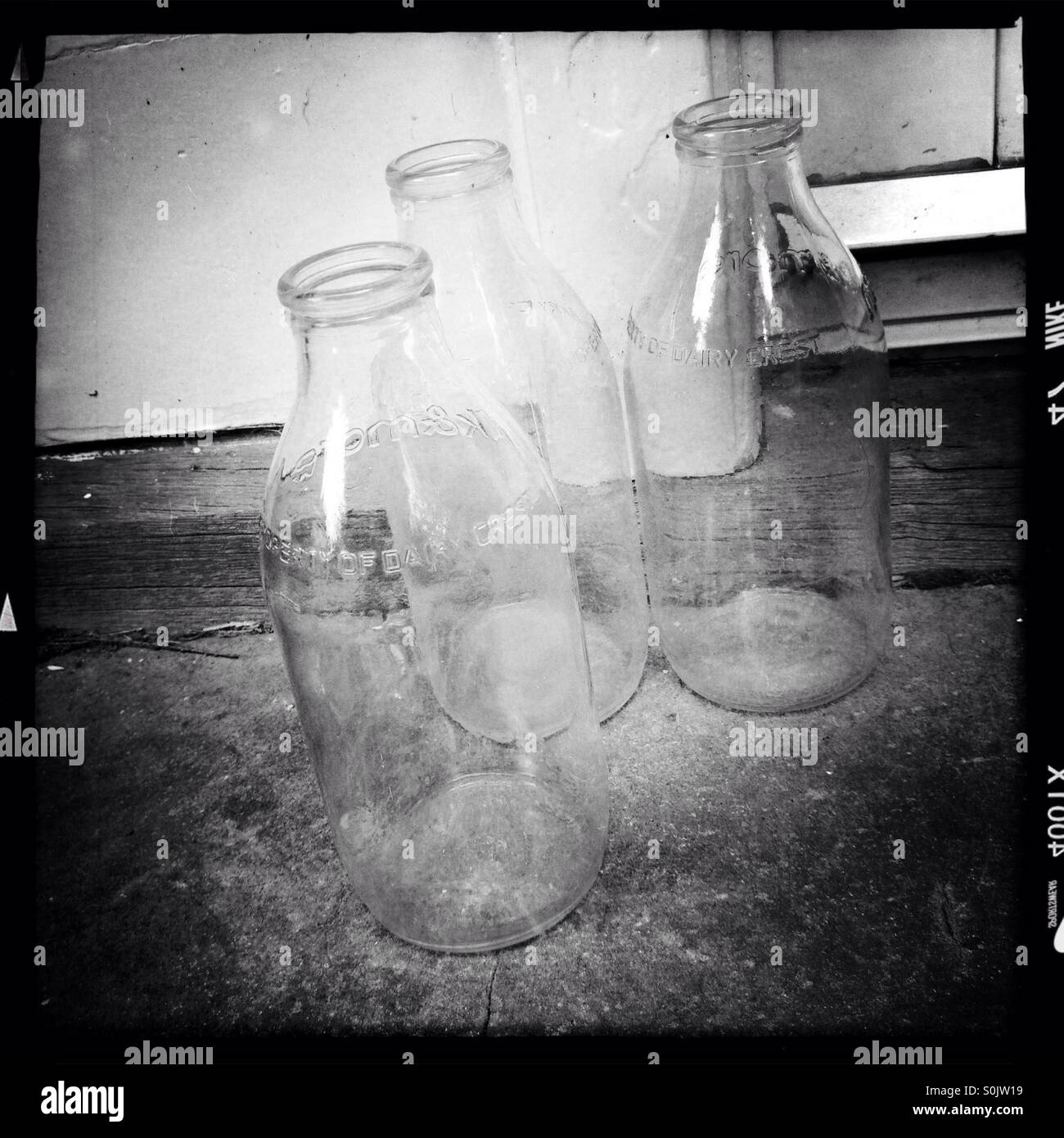 Empty milk bottles on a doorstep awaiting collection. Stock Photo