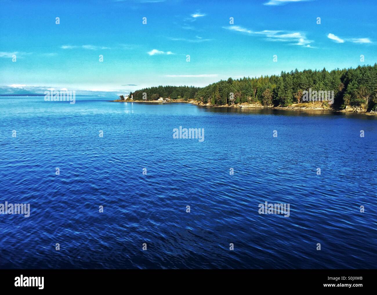 Sunny skies over an island in the Salish Sea in British Columbia. - Smartphone Captured Stock Image