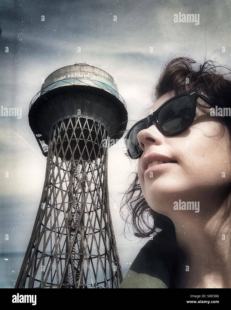 Selfie of woman in a sunglasses and water tower with sign Glory to Ukraine Stock Photo