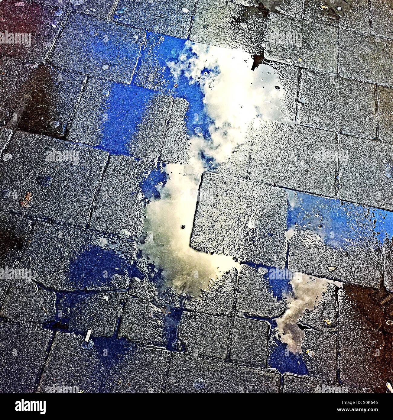 Rainy day. Cloud reflecting in puddle after a rainstorm. - Smartphone Captured Stock Image
