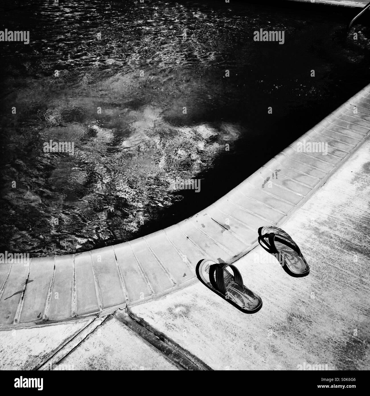 A pair of sandals next to a swimming pool. - Smartphone Captured Stock Image