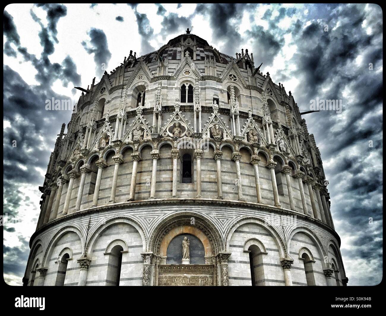 Dark Storm Clouds brew above the Baptistery in the Field of Miracles, Pisa, Tuscany, Italy. An HDR image, Photo Credit - COLIN HOSKINS. - Smartphone Captured Stock Image