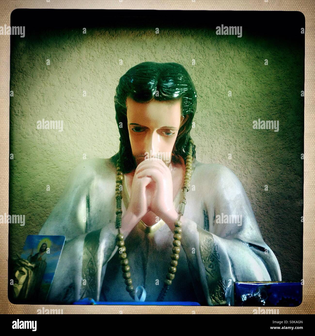 A sculpture of Jesus Christ thinking and praying decorates a house in Merida, Yucatan, Mexico - Smartphone Captured Stock Image