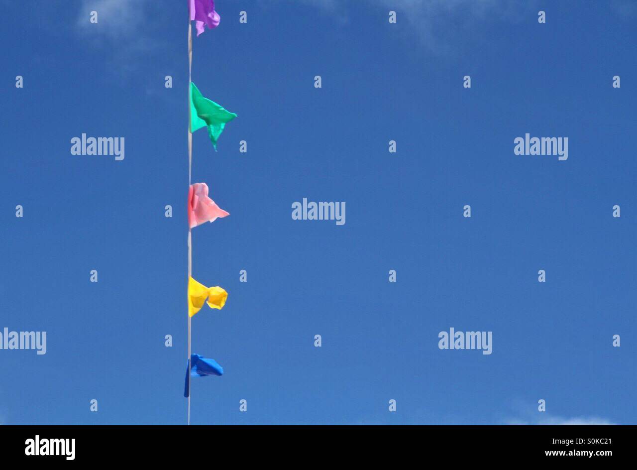Colourful bunting stretched across a bright blue sky - Smartphone Captured Stock Image