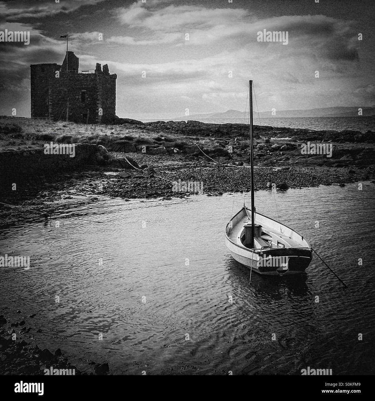 Small boat in Portencross harbour, with Portencross castle in the background, Ayrshire,Scotland - Smartphone Captured Stock Image