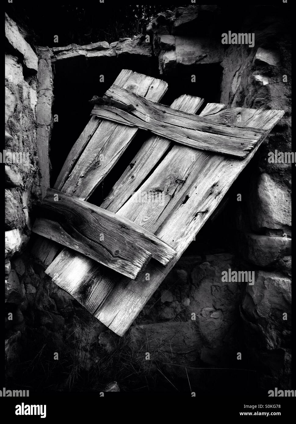 Old wooden door on a stone cistern building, Catalonia, Spain. - Smartphone Captured Stock Image