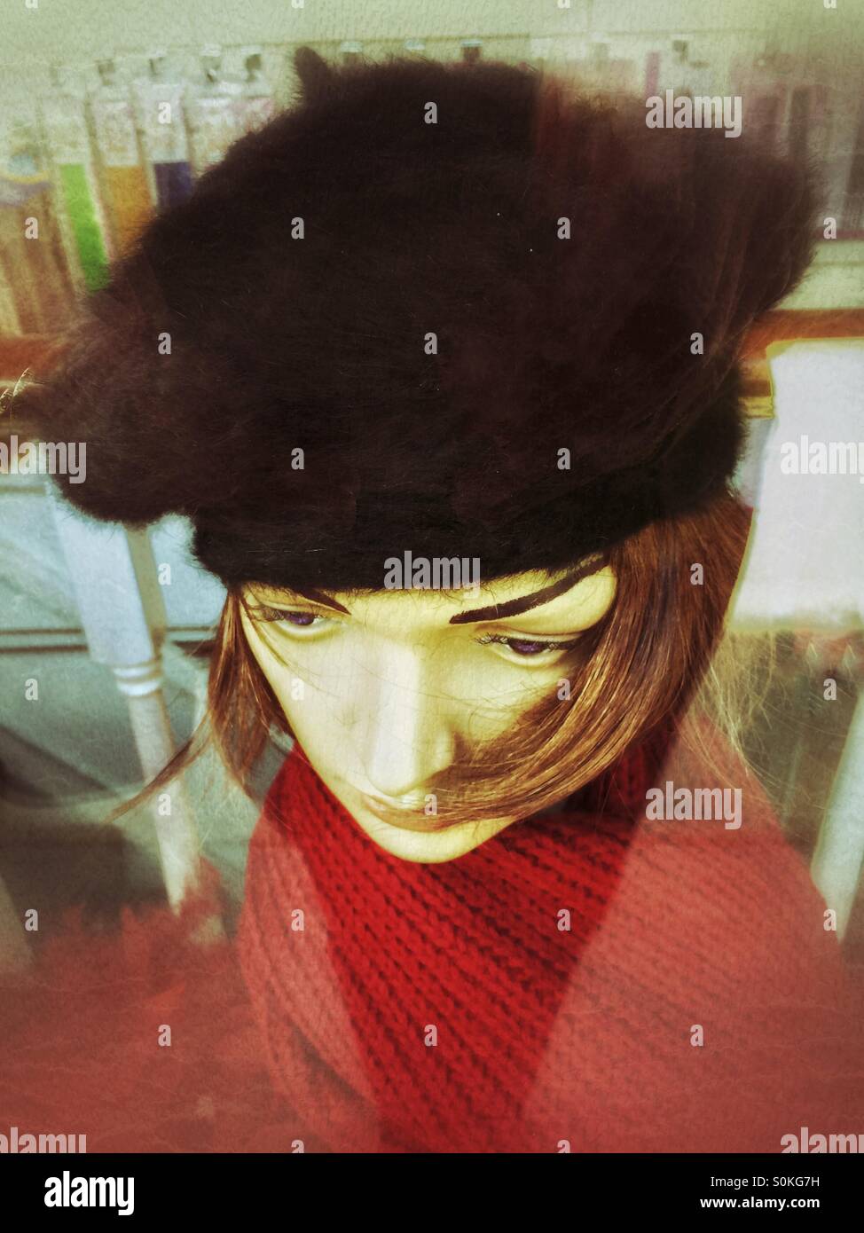 Shop mannequin head, in a shop window,wearing fur beret and red scarf. - Smartphone Captured Stock Image