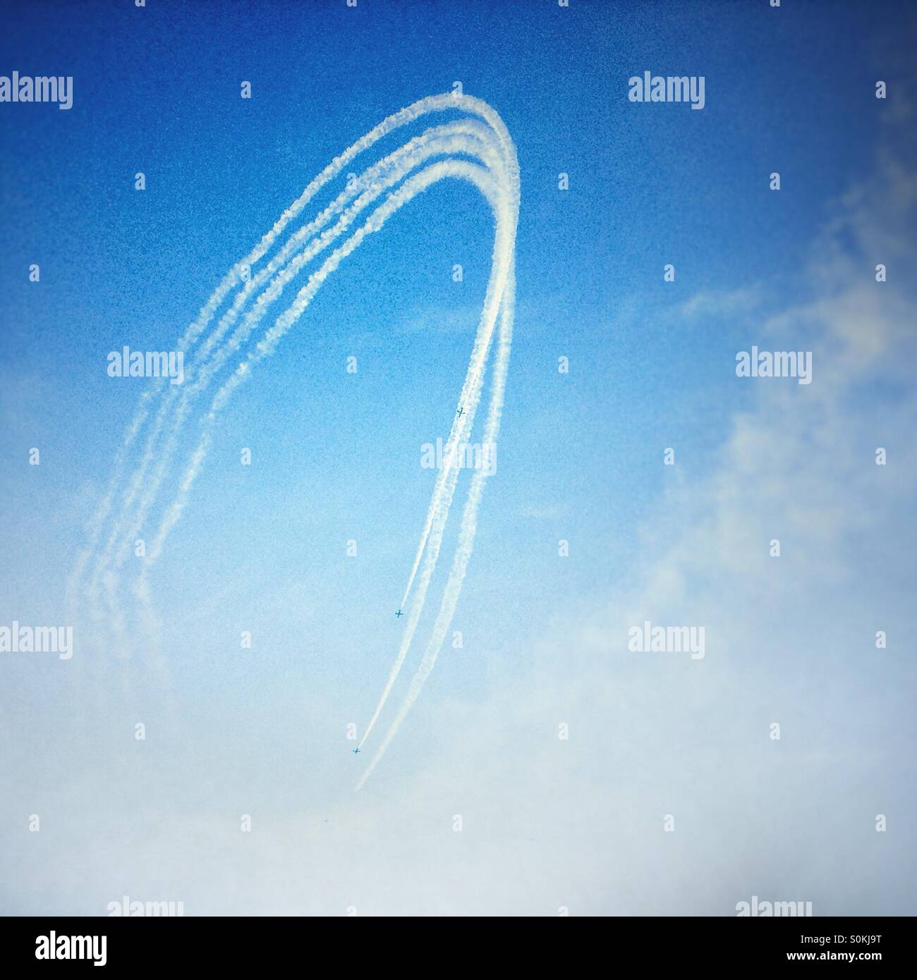 Four aeroplanes leave contrails in rhe blue sky - Smartphone Captured Stock Image