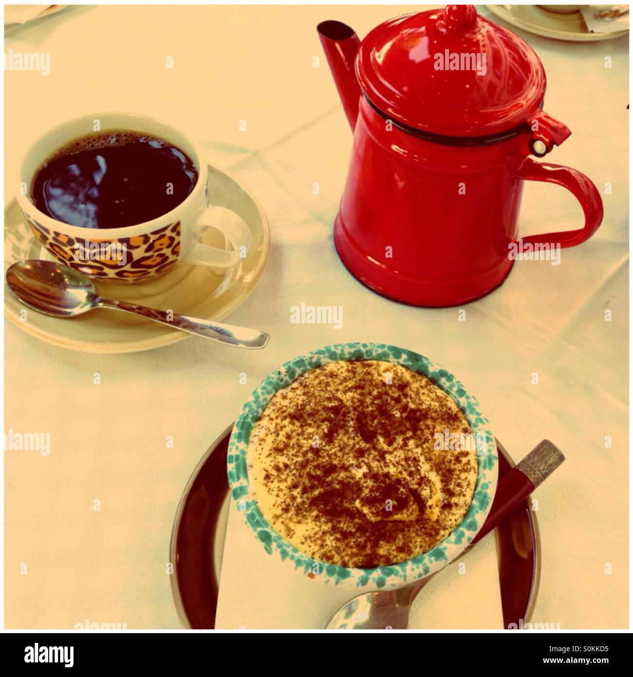 tiramisu with coffee in red kettle on the table Stock Photo