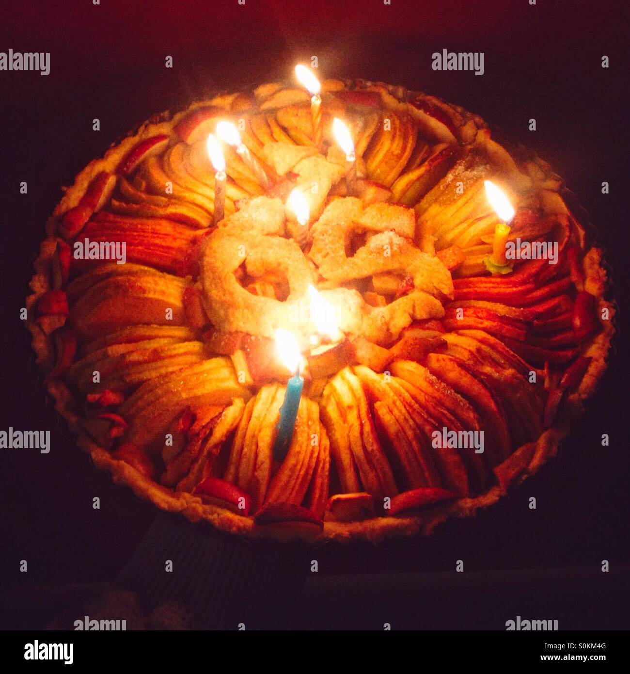 Apple tart 65th birthday cake with candles - Smartphone Captured Stock Image