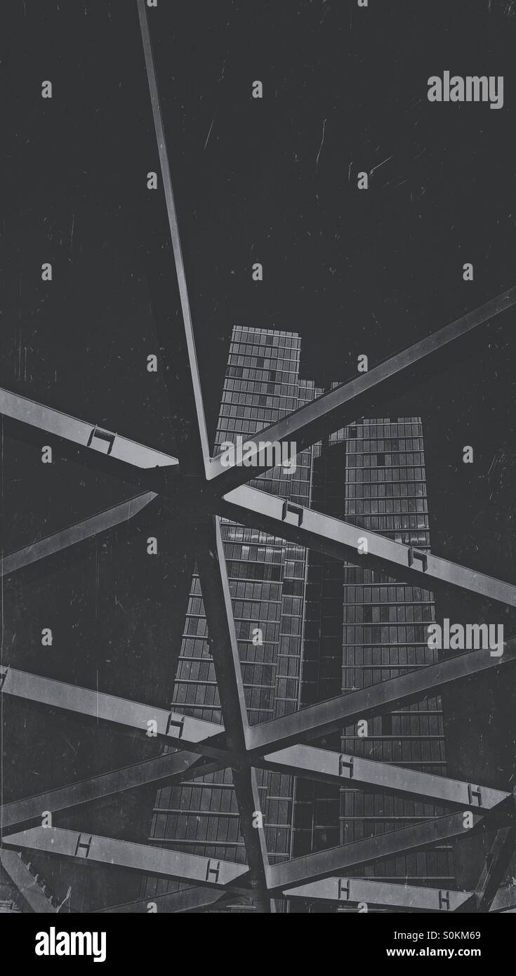 Retro black and white rendering of an office building seen through a metal framework - Smartphone Captured Stock Image