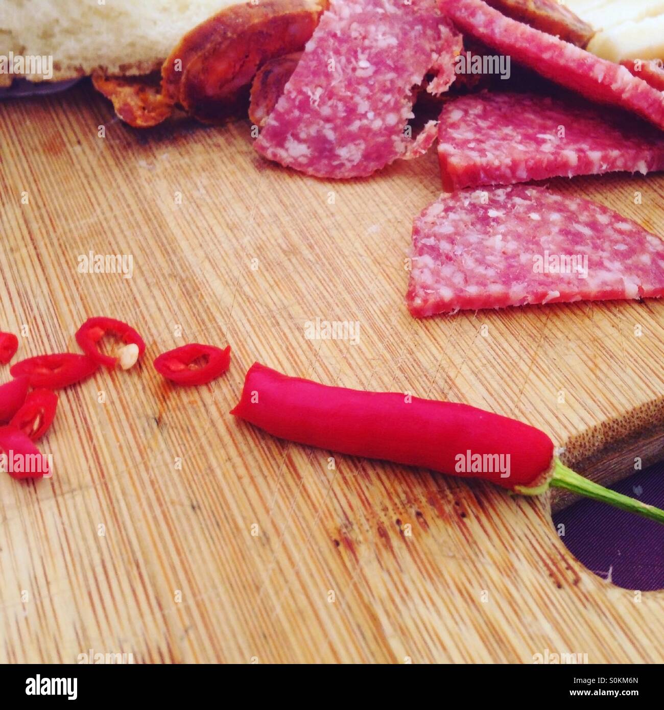 Spicy red chili pepper with salami sausage Stock Photo