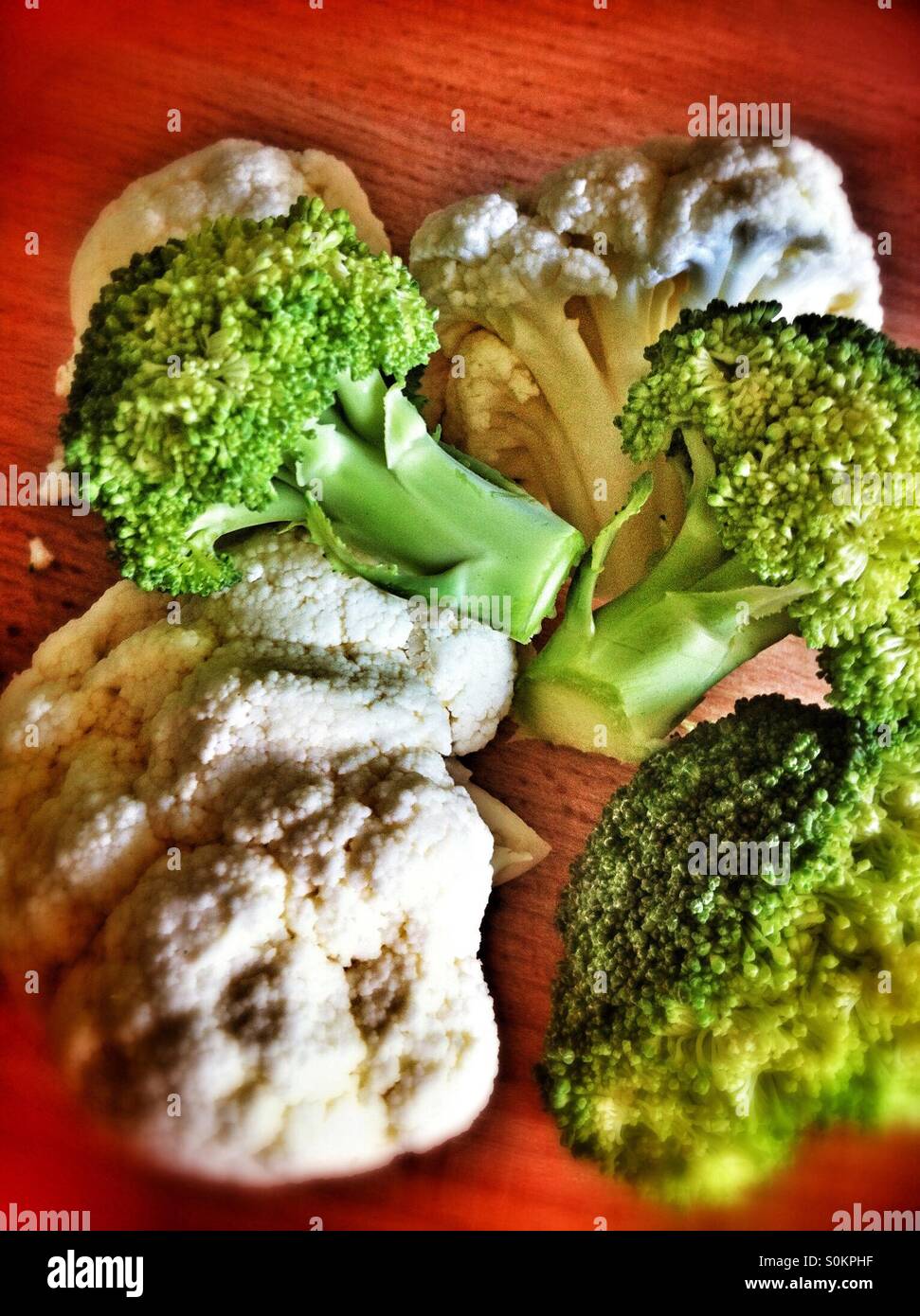 Close up of cauliflower and broccoli florets on chopping board - Smartphone Captured Stock Image