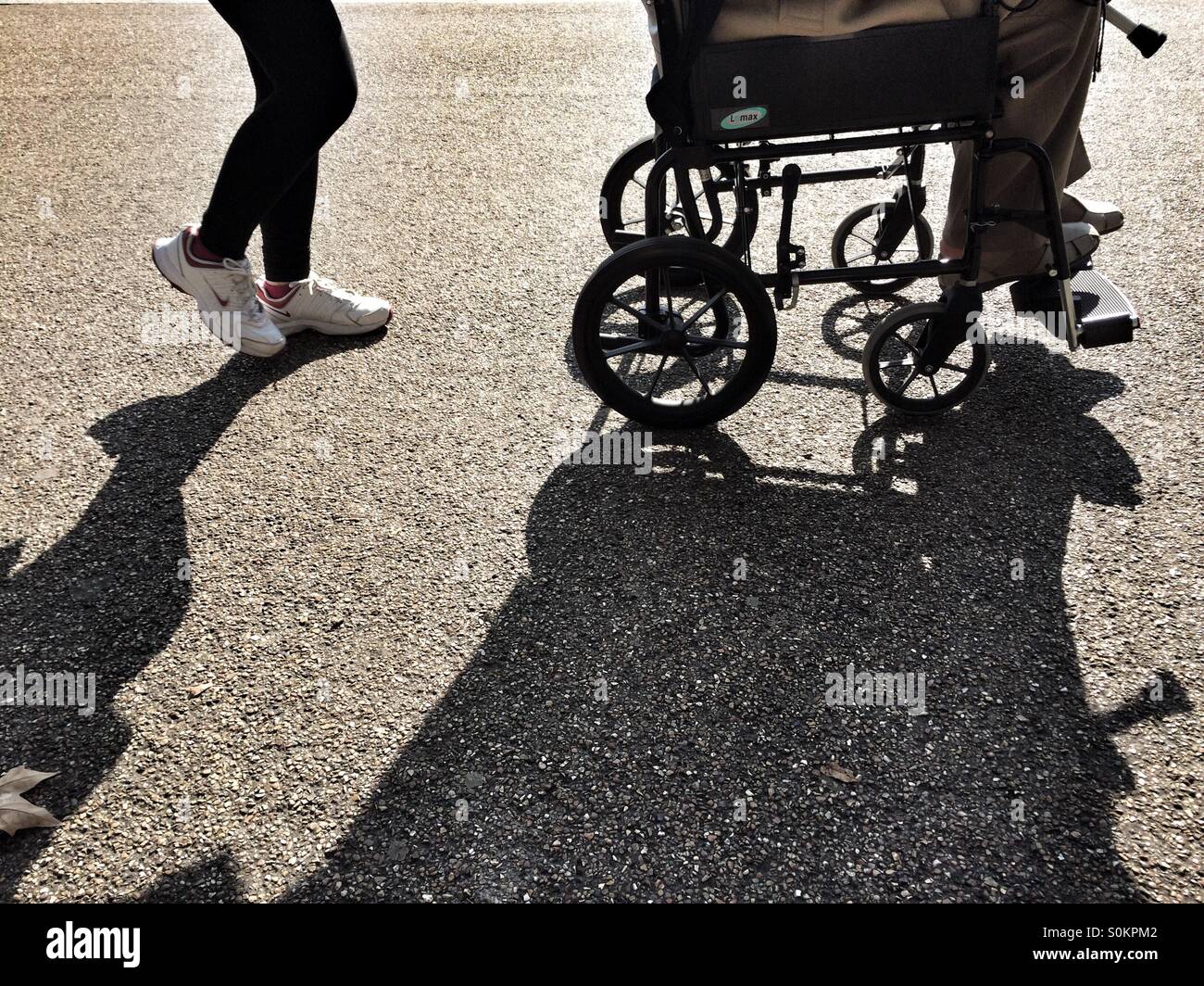 Pushing a wheelchair Stock Photo Alamy
