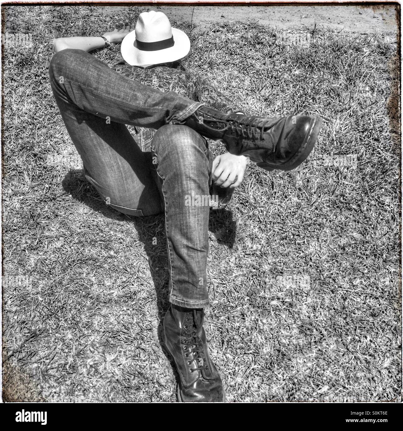 Man lying down with hat on face. - Smartphone Captured Stock Image